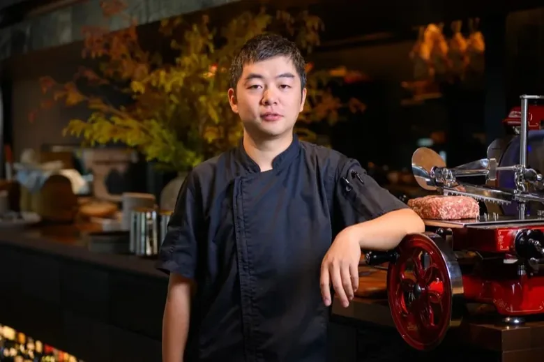 A chef standing at the counter of a partner restaurant.